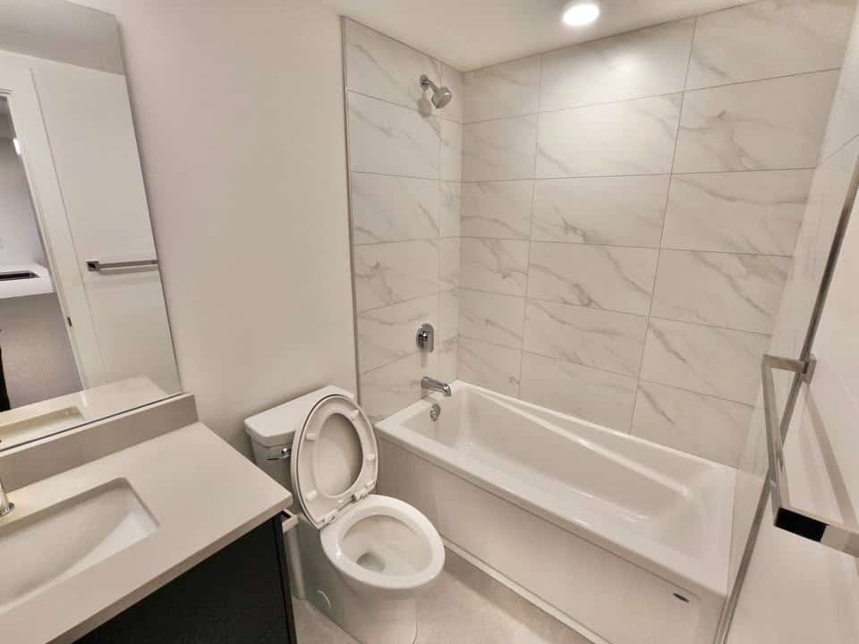 Modern bathroom with bathtub, white fixtures, and contemporary design, perfect for Vancouver real estate listings.
