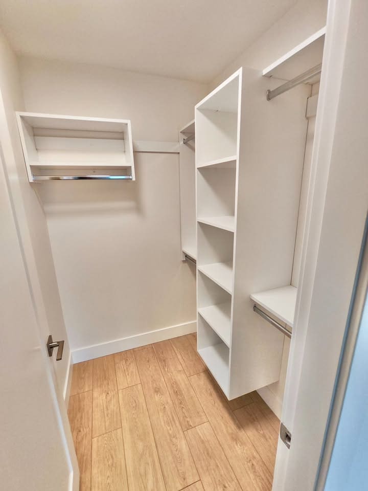 568215967_25086371461012681_7256130899139303003_n Closet interior with white shelving and hanging rods, modern storage space design, in a residential property in BC, Canada.