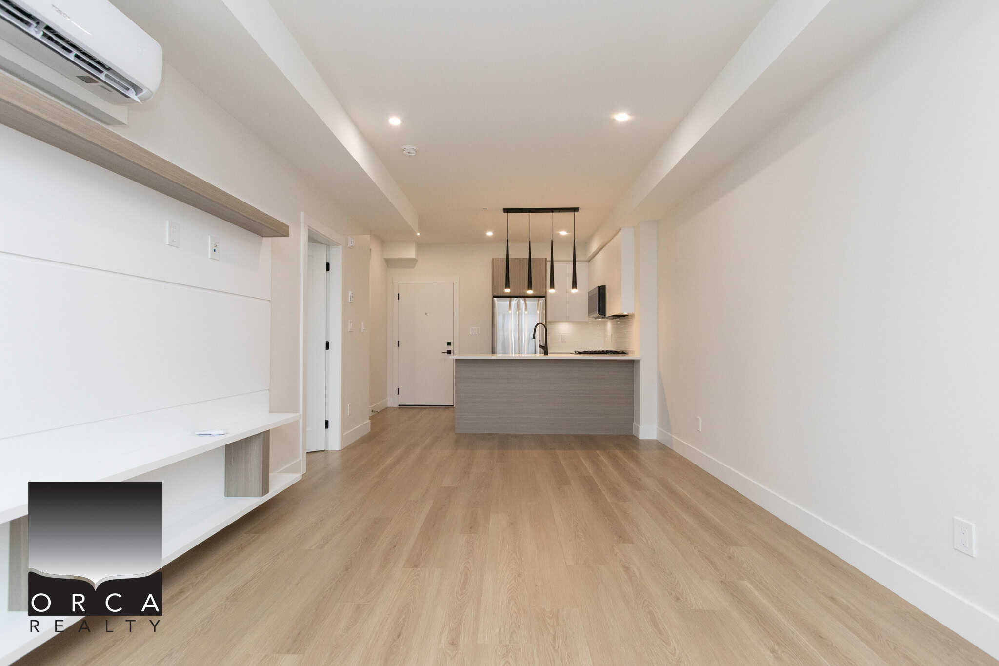 Modern open-concept kitchen and living space in a contemporary Vancouver apartment, featuring minimalist design, hardwood flooring, and stainless steel appliances, perfect for luxury urban living.