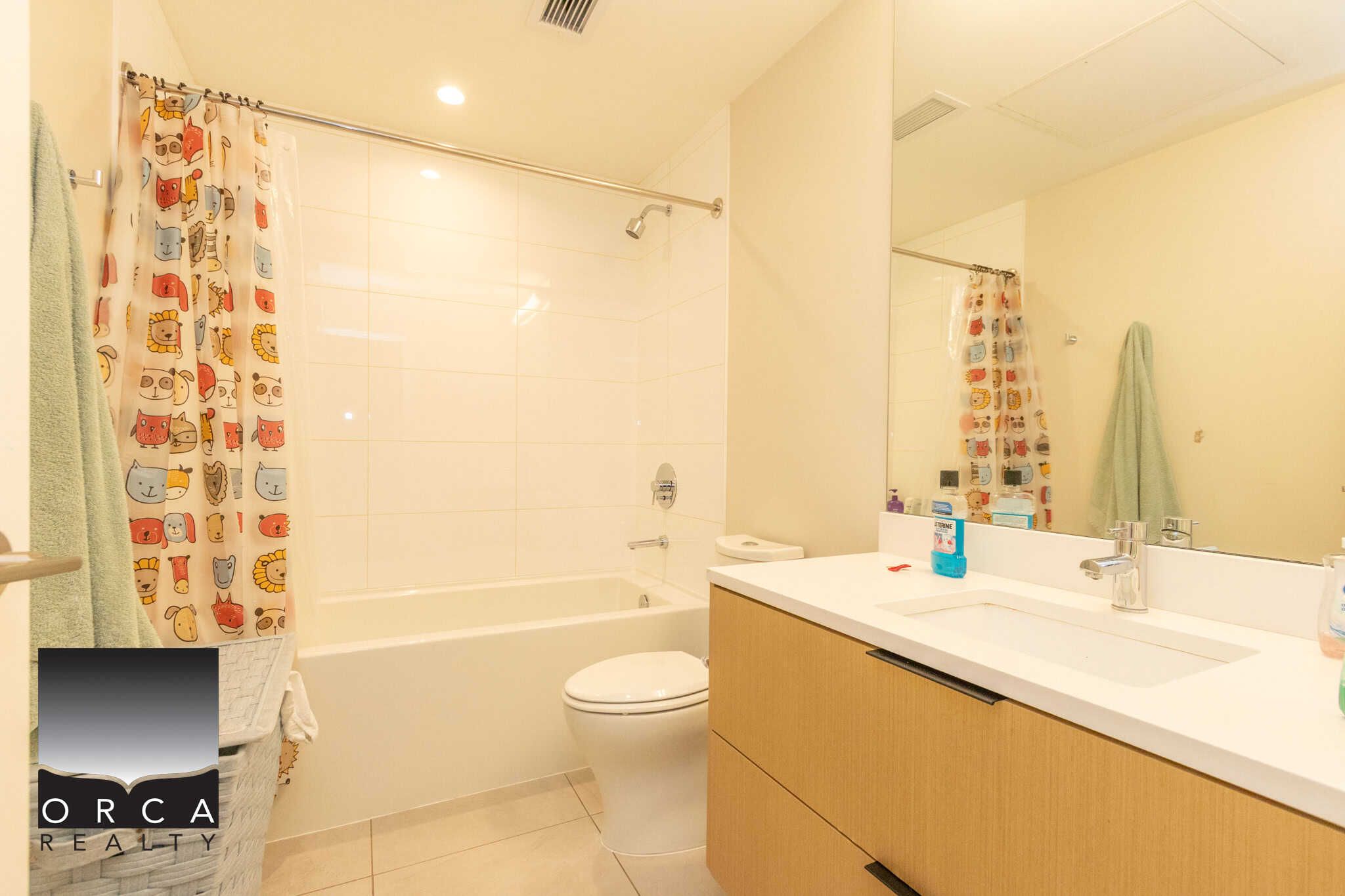 Bright and clean North Vancouver bathroom featuring a bathtub, shower, and modern vanity with mirror, ideal for homebuyers viewing 103-649 3rd Street East.