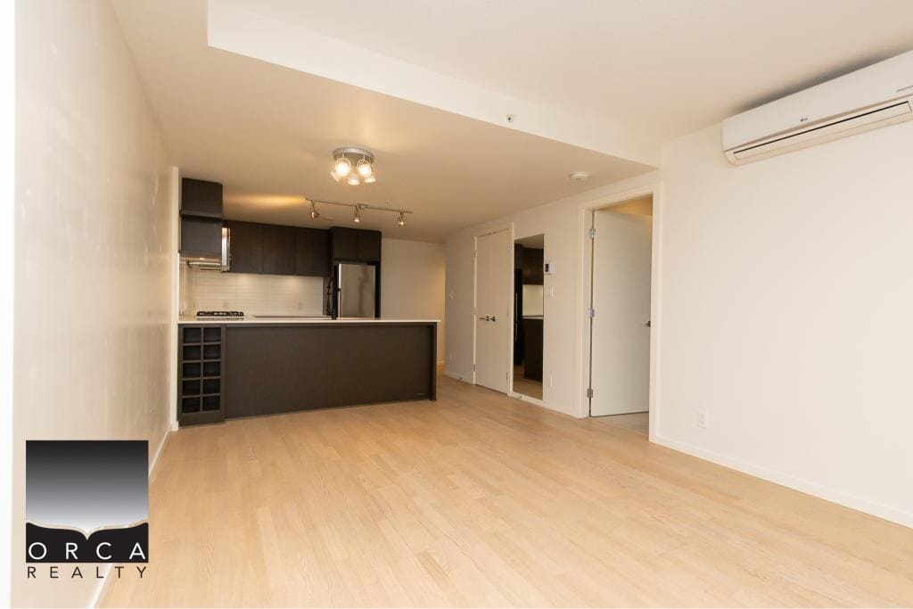 Modern open-concept living space with a sleek kitchen, ideal for Vancouver real estate buyers.