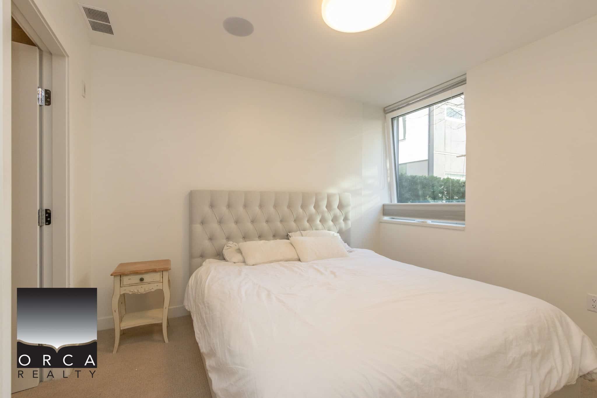 Bright North Vancouver bedroom with a large window and modern decor.