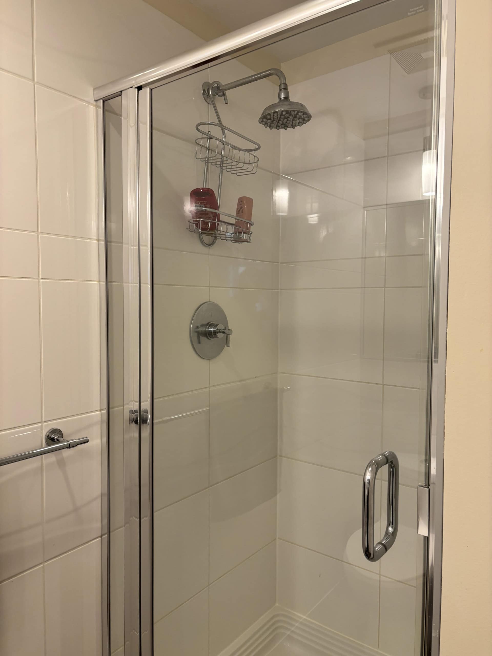 Shower stall with glass door, modern fixtures, and built-in shelving, ideal for Vancouver homes - Orca Realty Inc.