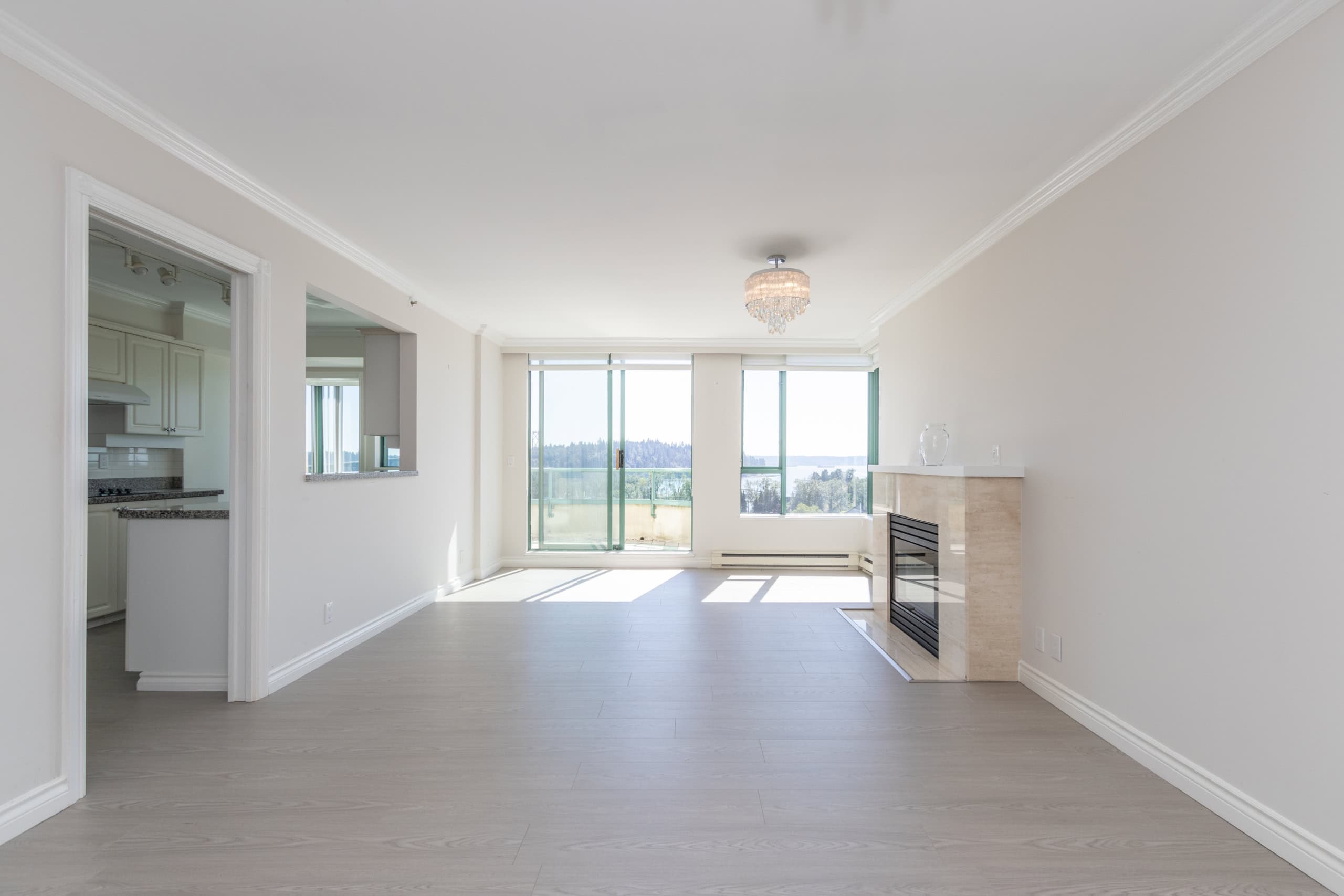 Bright open-concept living room with large windows and a fireplace, ideal for Vancouver area homes, featuring modern decor, natural light, and scenic views.