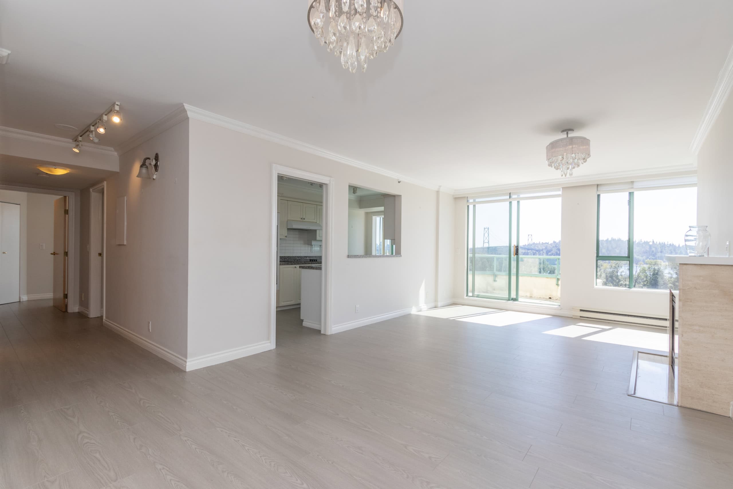 Bright modern apartment living room with large windows overlooking cityscape and skyline, featuring open-concept design, neutral decor, and abundant natural light, ideal for Vancouver real estate.