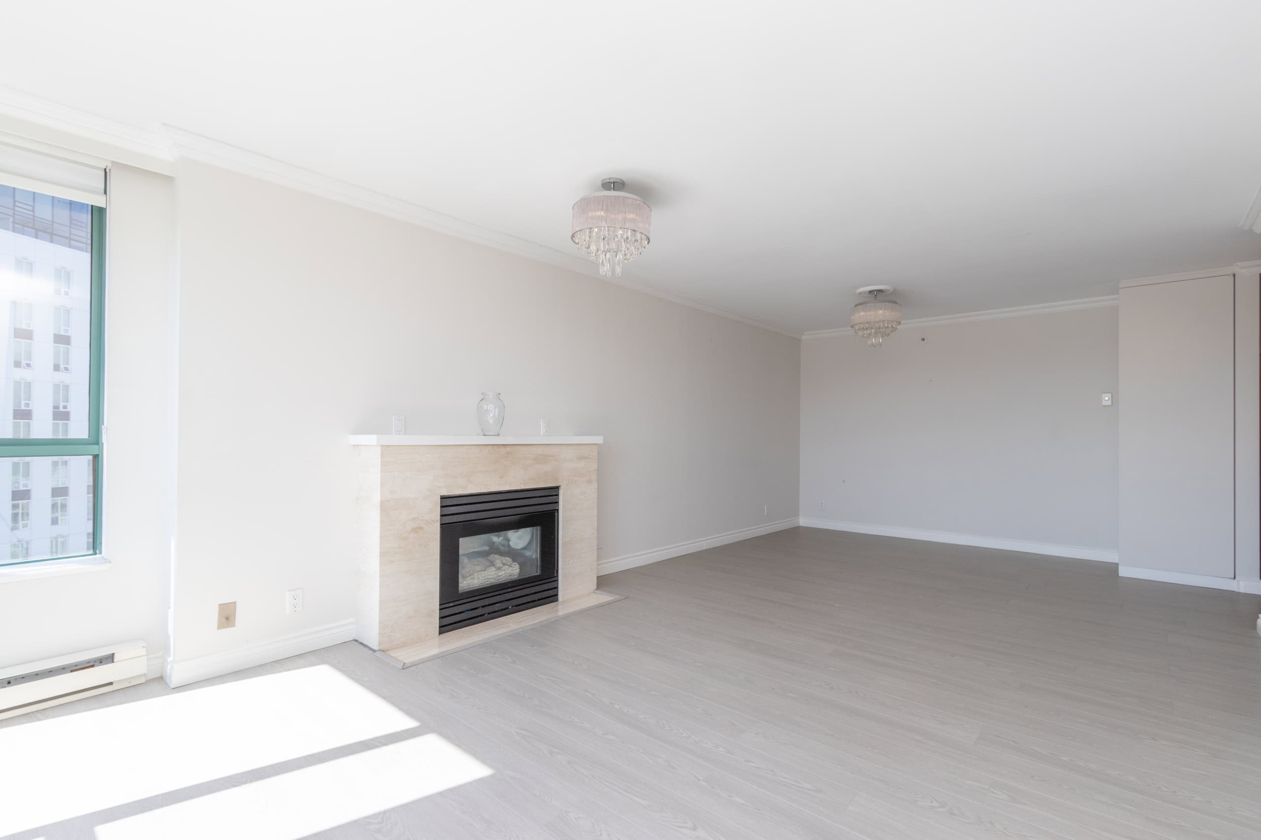 Bright, spacious living room with natural light, modern fireplace, and elegant interior details in a Vancouver condominium listing by Orca Realty Inc.