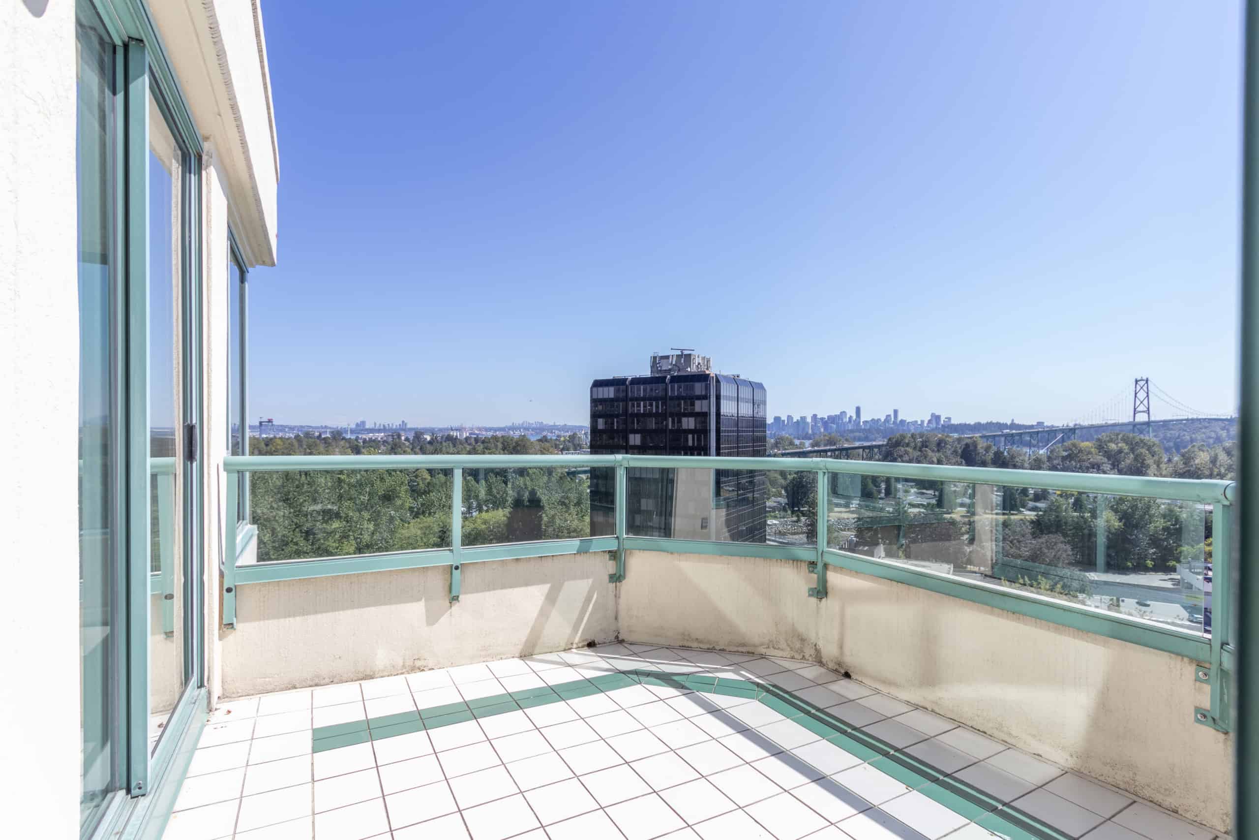 Panoramic city view from a balcony in Vancouver, showcasing modern urban living with skyline and bridge in the distance. Perfect for real estate listings highlighting condo features.
