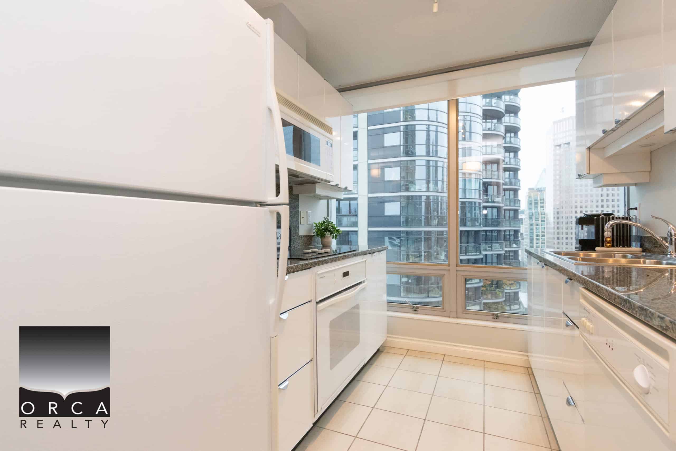 IMG_1720 Modern cityview kitchen with white appliances and granite countertops in a downtown Vancouver condo for sale or rent.