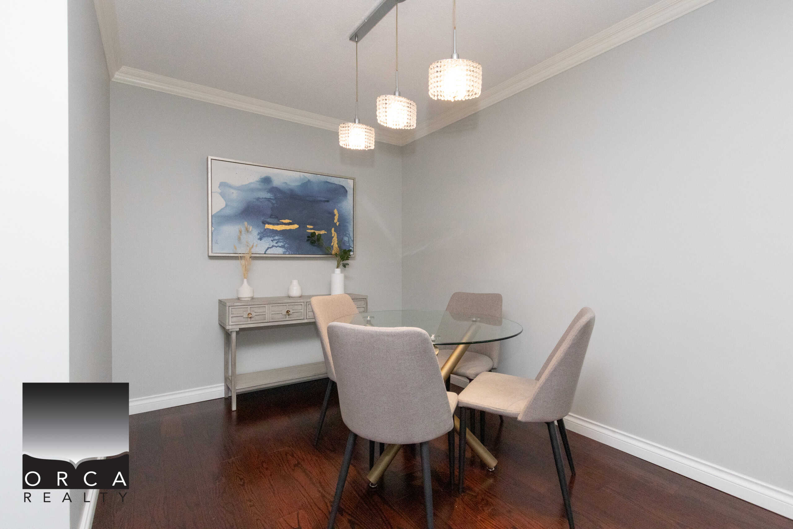 IMG_1737 Contemporary dining room with modern decor, glass table, and upholstered chairs, ideal for entertaining or family gatherings, featuring elegant lighting and stylish artwork.