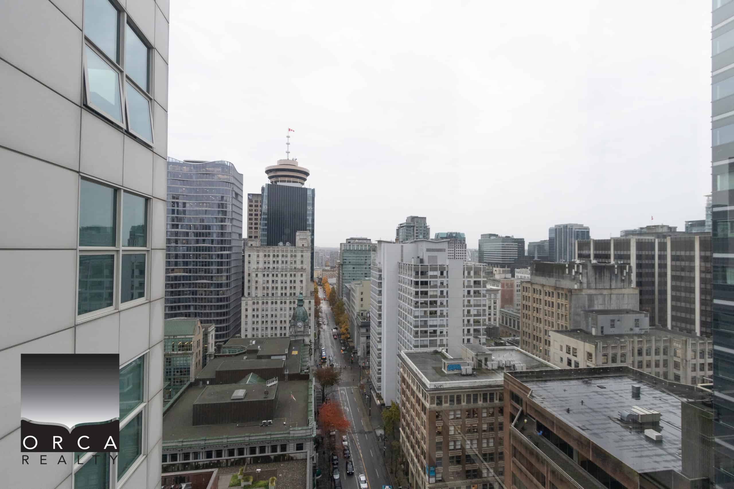 IMG_1756 Bright downtown Vancouver cityscape viewed from a high-rise apartment window, showcasing modern office buildings and urban infrastructure emphasizing real estate opportunities.