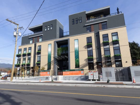 Contemporary multi-story residential building with modern design, large windows, and balconies, situated along a city street offering prime Vancouver real estate opportunities.