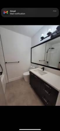 Modern bathroom interior with vanity, mirror, and toilet in contemporary home decor.