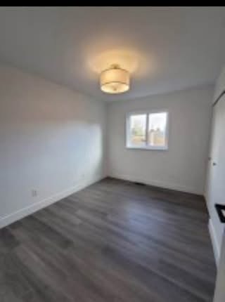 Bright empty bedroom with white walls, large window, and modern flooring, ideal for Vancouver Island real estate listings.