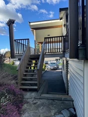Modern outdoor staircase leading to a second-floor deck in a residential property in British Columbia, showcasing quality craftsmanship.
