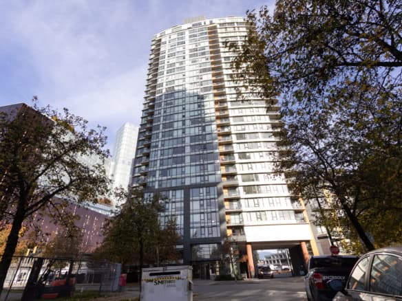 Luxurious modern high-rise apartment building in Vancouver, BC, featuring glass exterior and spacious balconies, ideal for urban living and investment opportunities in the real estate market.