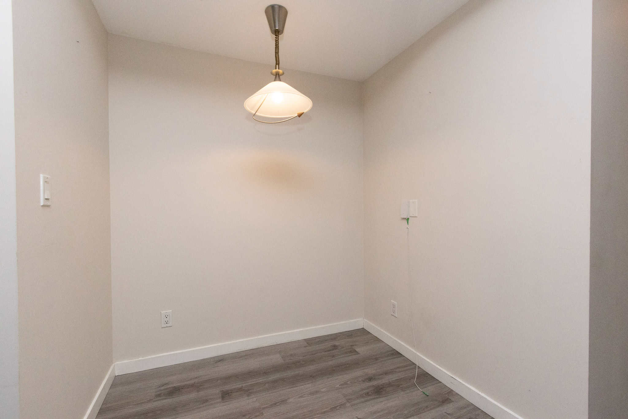 Bright empty room with modern flooring and ceiling light, ideal for real estate staging, showcasing properties for sale or rent by Orca Realty Inc. in Vancouver.