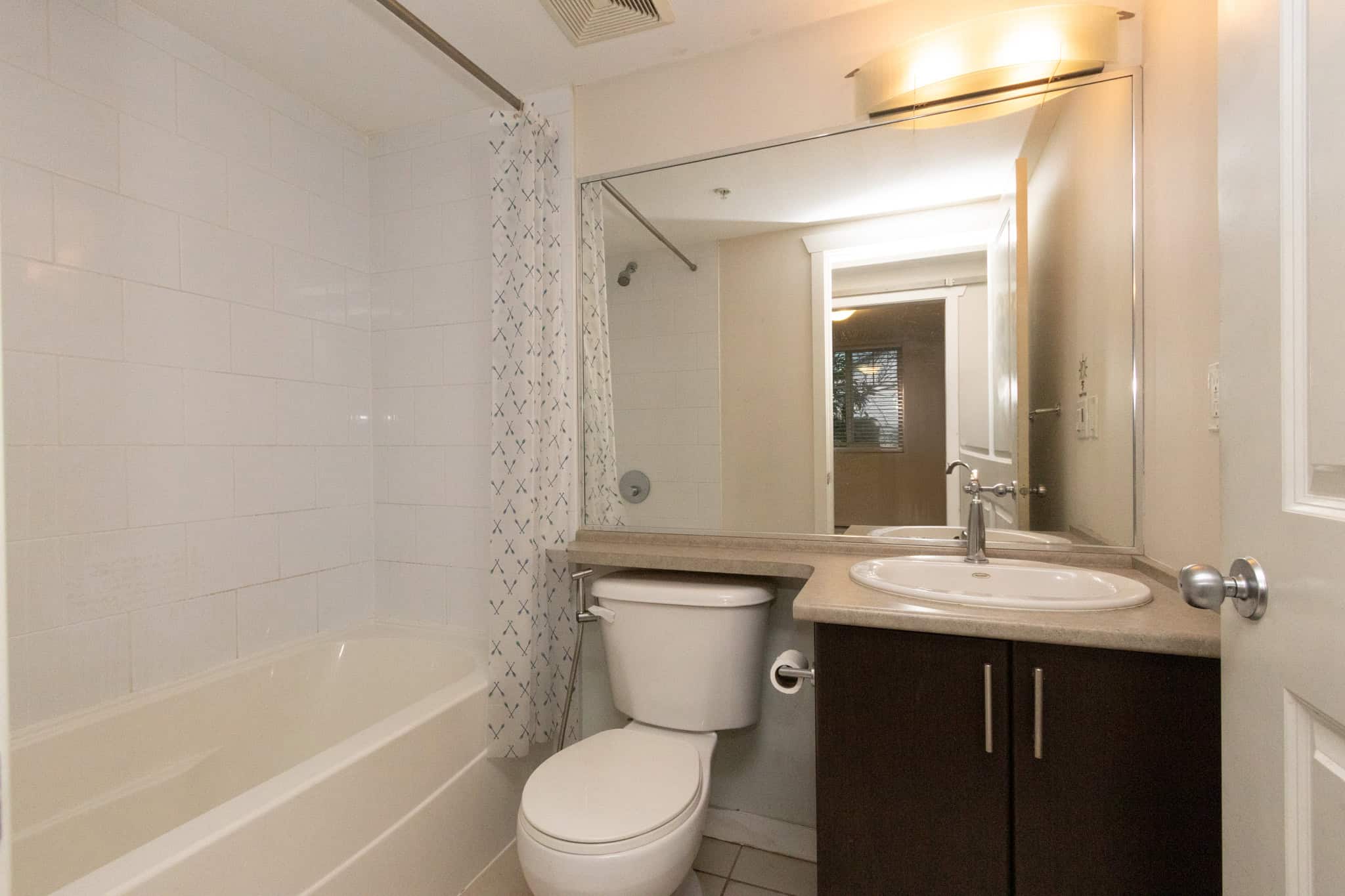 Modern bathroom featuring a bathtub, white tiles, and a stylish vanity with sink, ideal for Vancouver real estate listings and property sales.