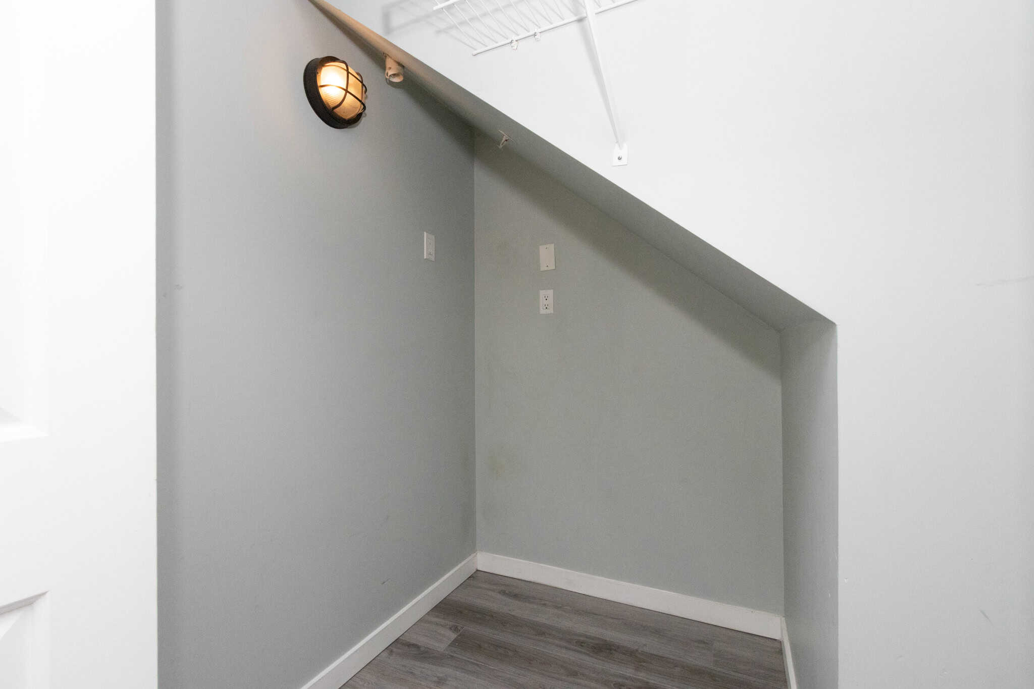Bright interior corner of a modern home with soft grey walls, electrical outlets, and contemporary lighting, showcasing quality real estate features by Orca Realty Inc. in Canada.