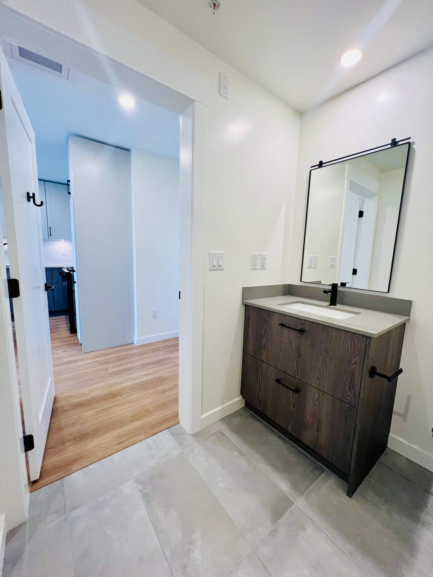 IMG_5605 Modern bathroom vanity with a framed mirror and wood cabinetry, bright LED lighting, and sleek design, perfect for contemporary homes in Vancouver and surrounding areas.