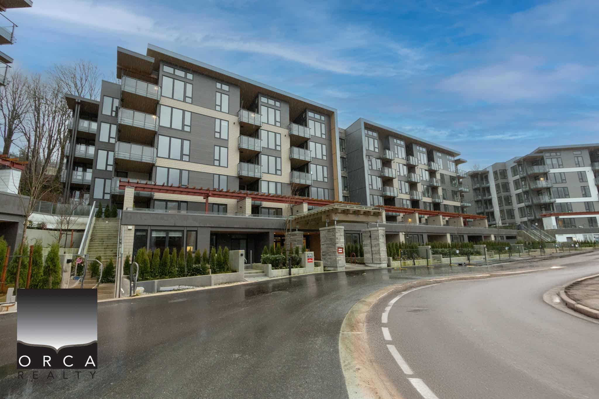 Modern waterfront condo buildings in Vancouver with contemporary architecture and lush landscaping, ideal for real estate investment or residential living.