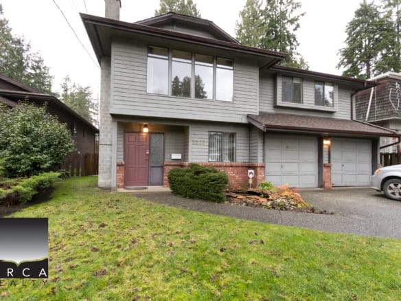 Spacious B.C. family home with modern updates, large windows, shaded porch, well-maintained yard, and two-car garage, perfect for comfortable living and investment in the real estate market.