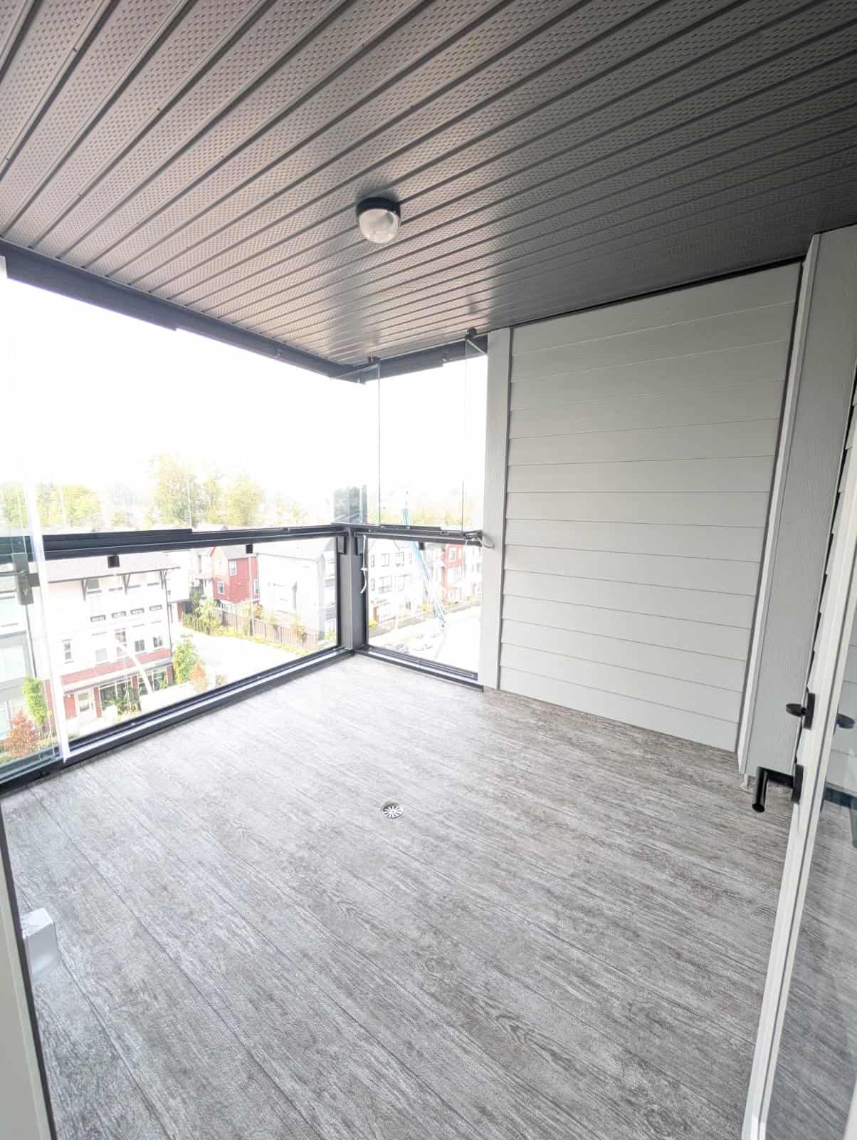 1-3 Spacious balcony with glass railing and city views, perfect for relaxing or entertaining, located in a modern residential building in Vancouver.