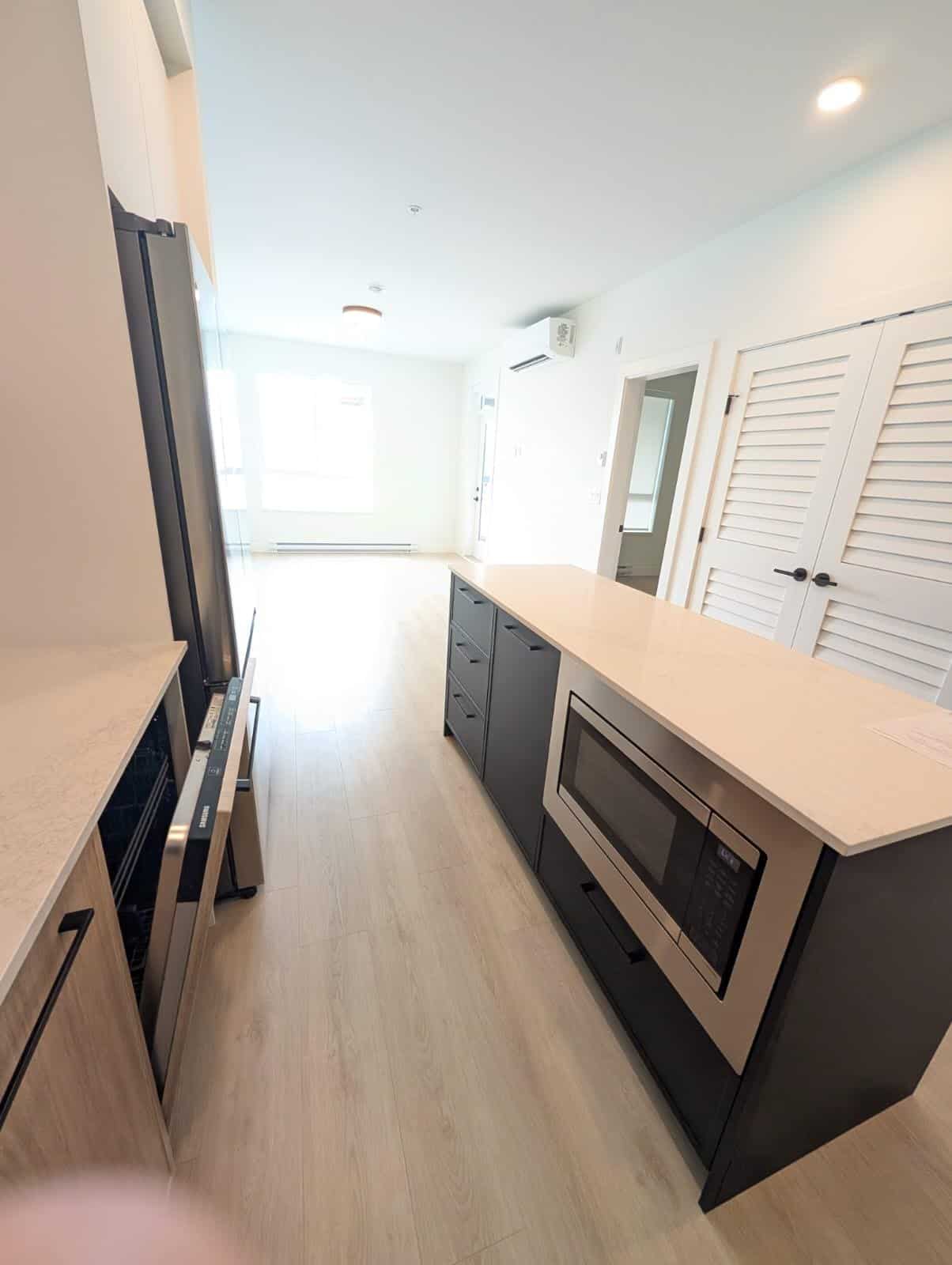 1-6 Bright modern kitchen with stainless steel appliances, white countertops, and light wood flooring, perfect for Vancouver-area homes.