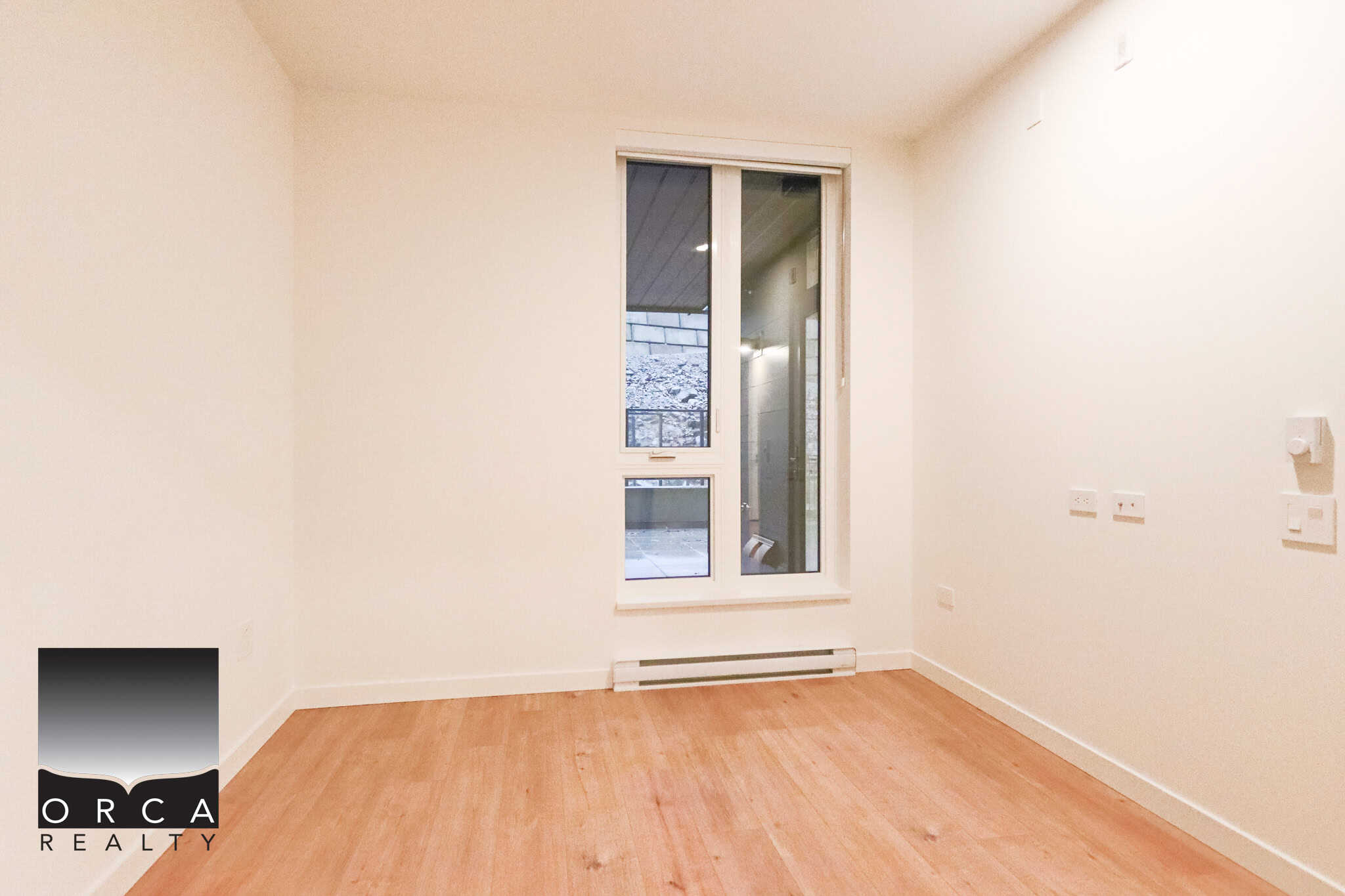 Bright empty room with large window, ideal for Vancouver property, featuring hardwood floors and modern interior. Perfect for real estate listings or housing market marketing in BC.