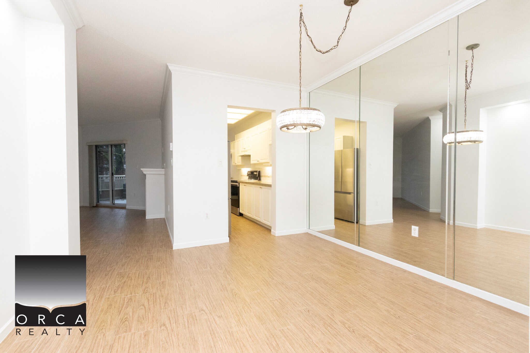 Bright, modern interior of Vancouver area home showcasing hardwood floors, mirrored wall, spacious kitchen, and elegant lighting fixtures, perfect for contemporary living.