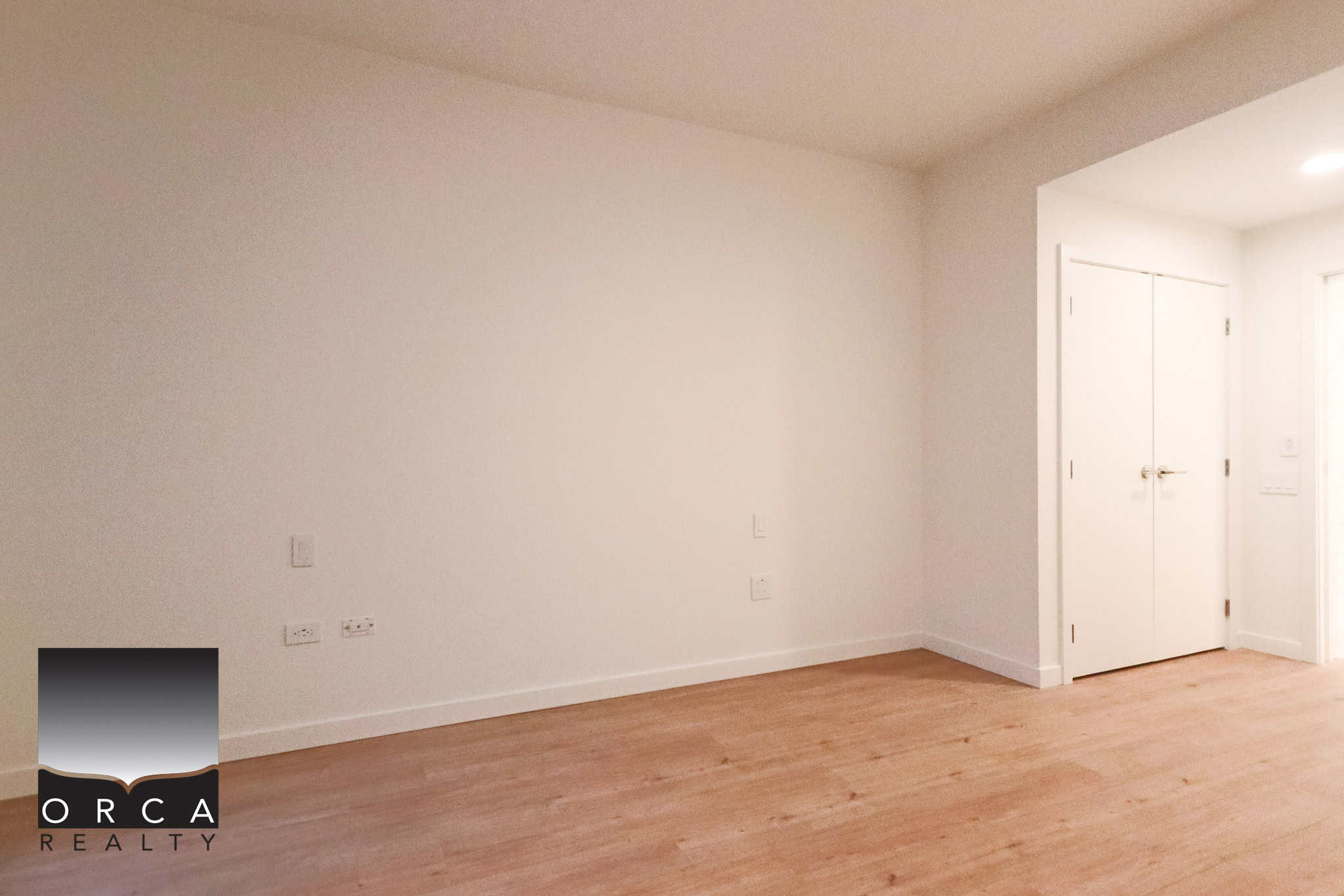 Bright, empty living space with white walls and natural wood flooring, perfect for homebuyers seeking modern Vancouver real estate options.