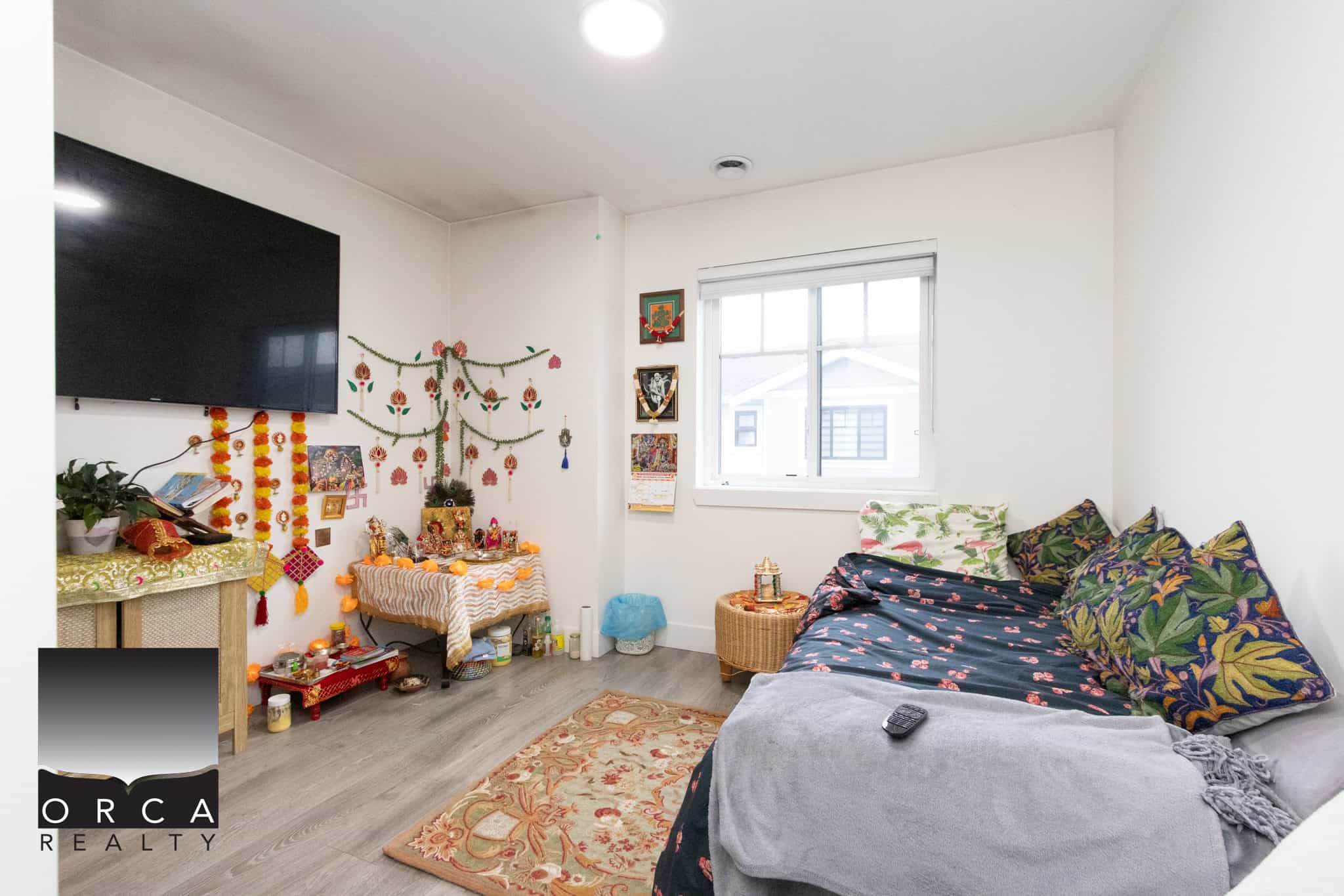 15 Colourful living room decorated with traditional Indian spiritual items, wall hangings, and vibrant cushions, showcasing a cozy and culturally rich home interior from Orca Realty Inc.