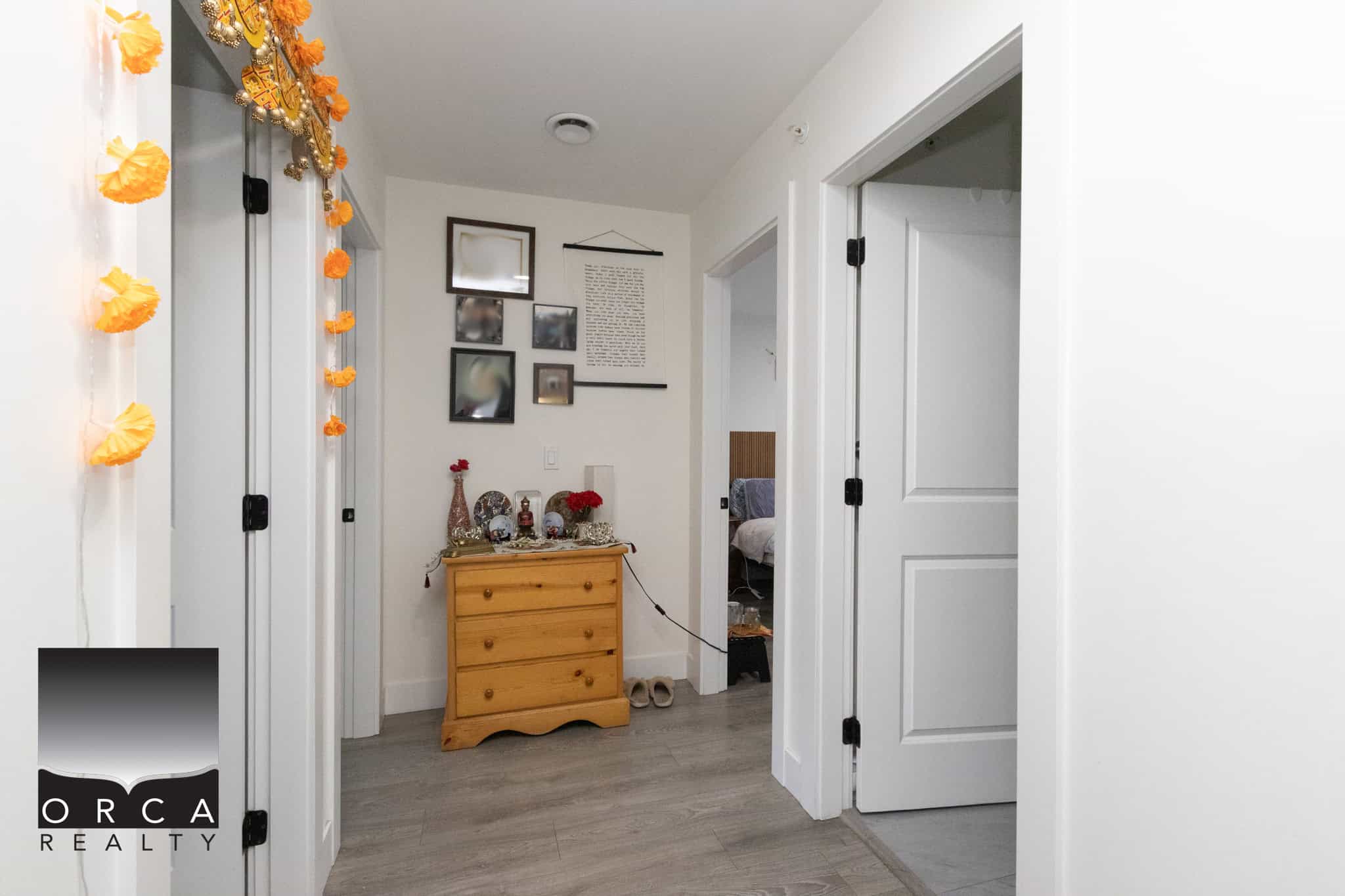 18 Bright and modern interior view of a home for sale by Orca Realty Inc., showcasing white doors, stylish wall decor, and cozy living space ideal for Canadian homeowners.