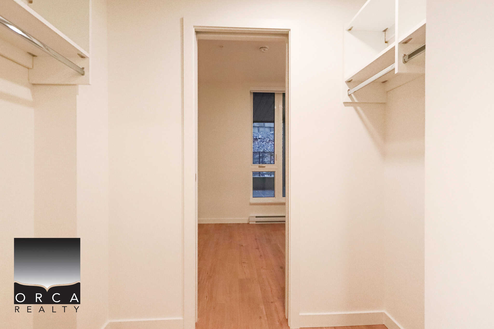 Spacious walk-in closet with built-in shelving and hanging space in a modern home, ideal for organizing clothing and accessories, featuring natural light and hardwood flooring.