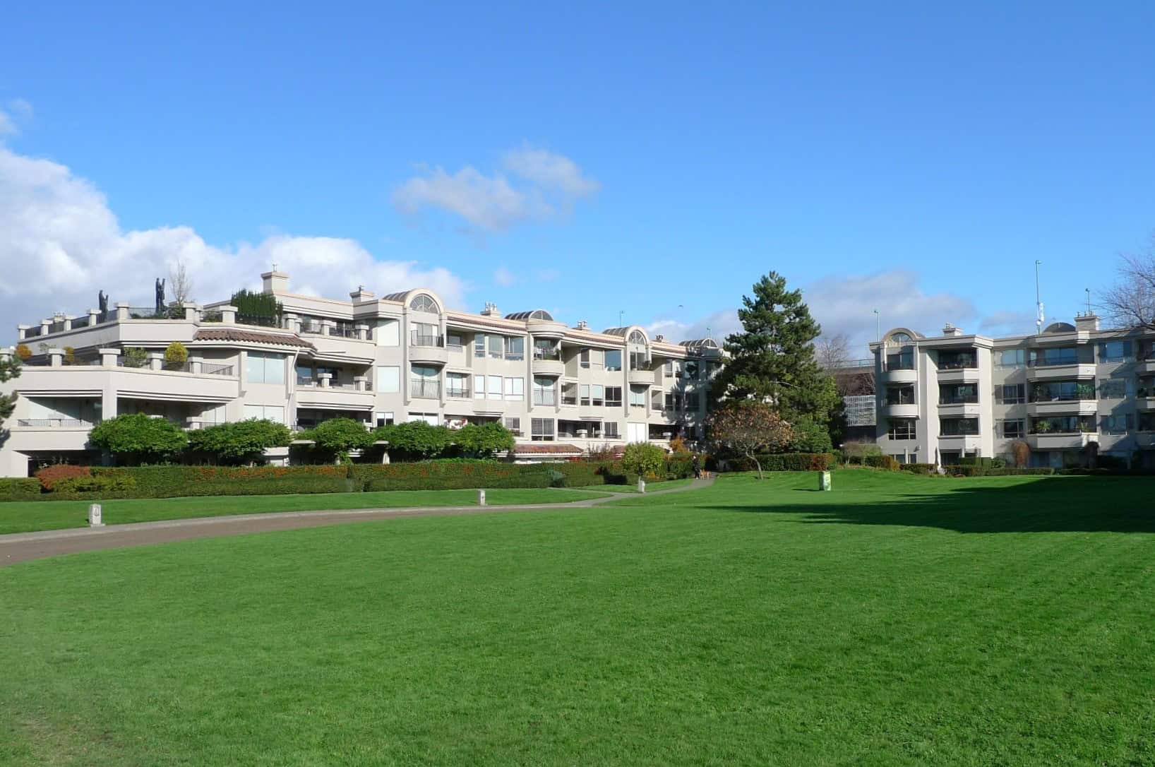 Luxurious residential apartment building with landscaped green lawn, situated in a scenic and peaceful neighbourhood, ideal for comfortable living and real estate investment in British Columbia.