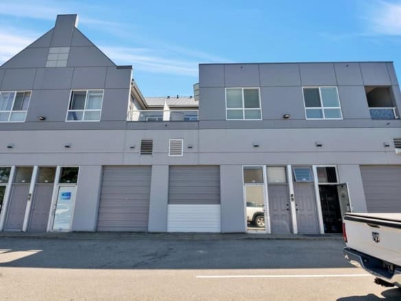 Modern multi-unit commercial building with garage doors, storefronts, easy access, ideal for businesses and real estate investment in Vancouver.