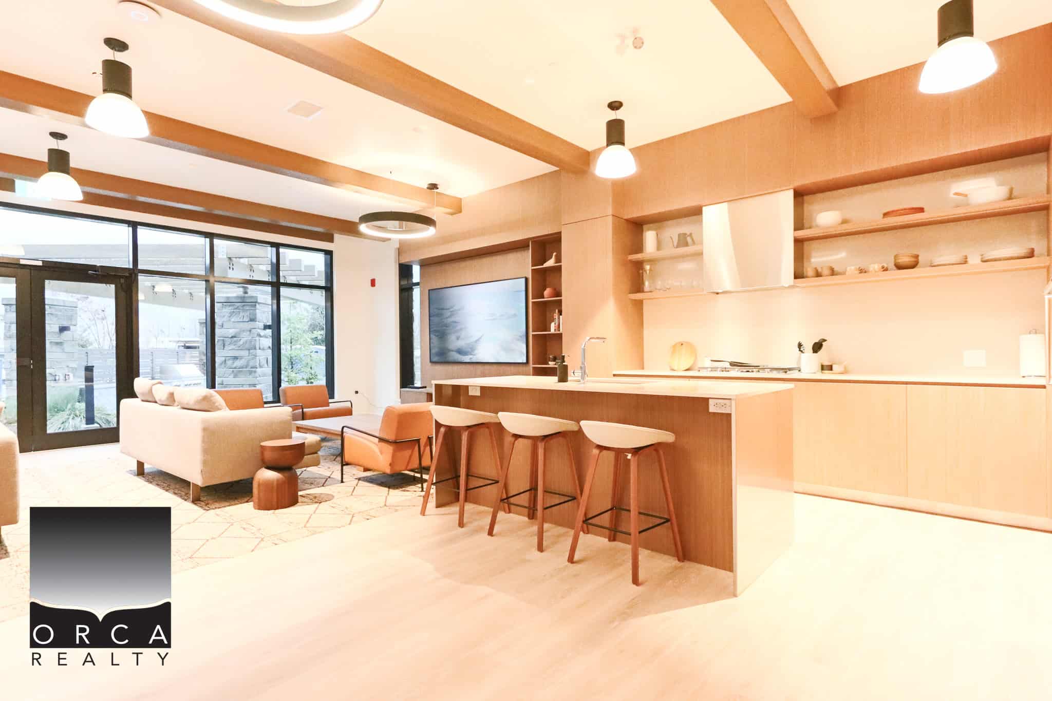 Modern open-concept kitchen and lounge area featuring warm wood accents, stylish lighting, and contemporary furnishings, perfect for Vancouver real estate and property rentals.