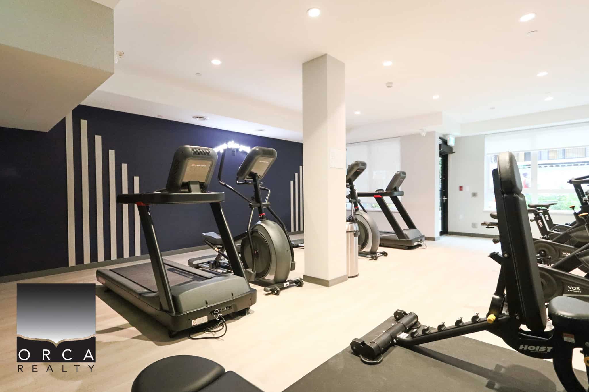 25 Modern fitness center with cardio machines including treadmills, exercise bikes, and workout equipment, perfect for residents seeking convenient health and wellness amenities at Orca Realty Inc.