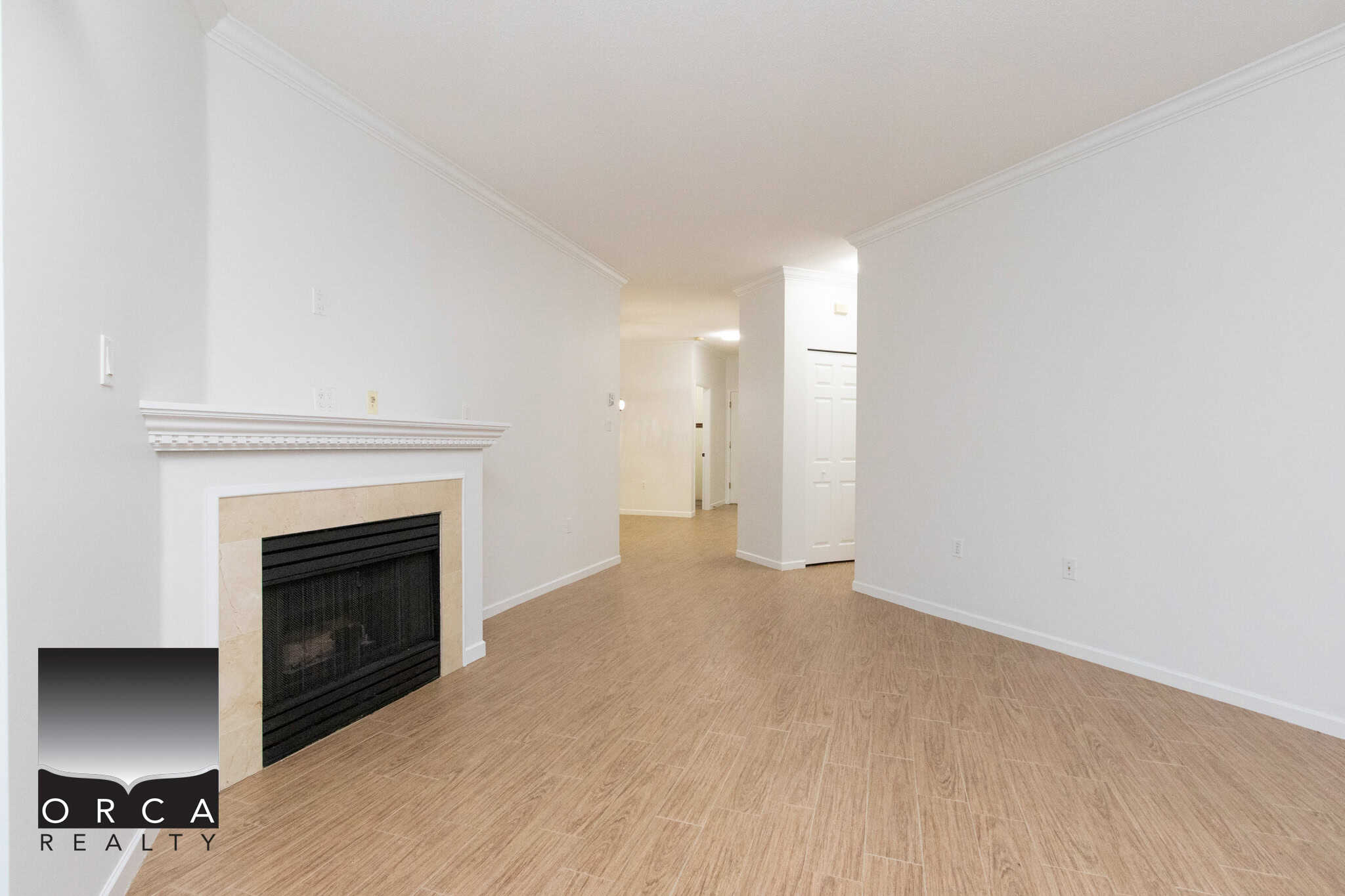 Spacious living room with neutral décor, modern fireplace, and hardwood flooring, perfect for homeowners seeking comfortable housing options in the Vancouver area.