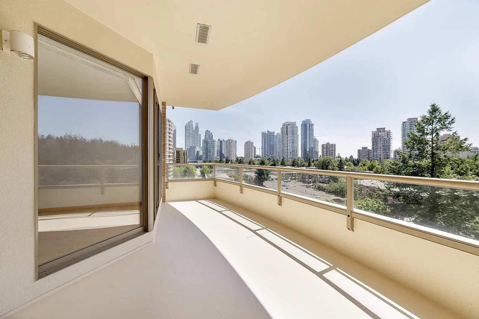 Bright modern balcony with city skyline views in Vancouver, BC, showcasing upscale condo living with spacious outdoor space, ideal for urban lifestyle enthusiasts.
