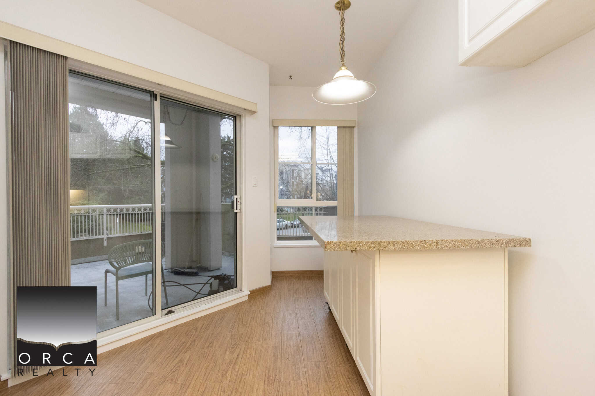 Bright and spacious kitchen with sliding glass door leading to balcony, ideal for condo living and urban homes in Vancouver, BC.