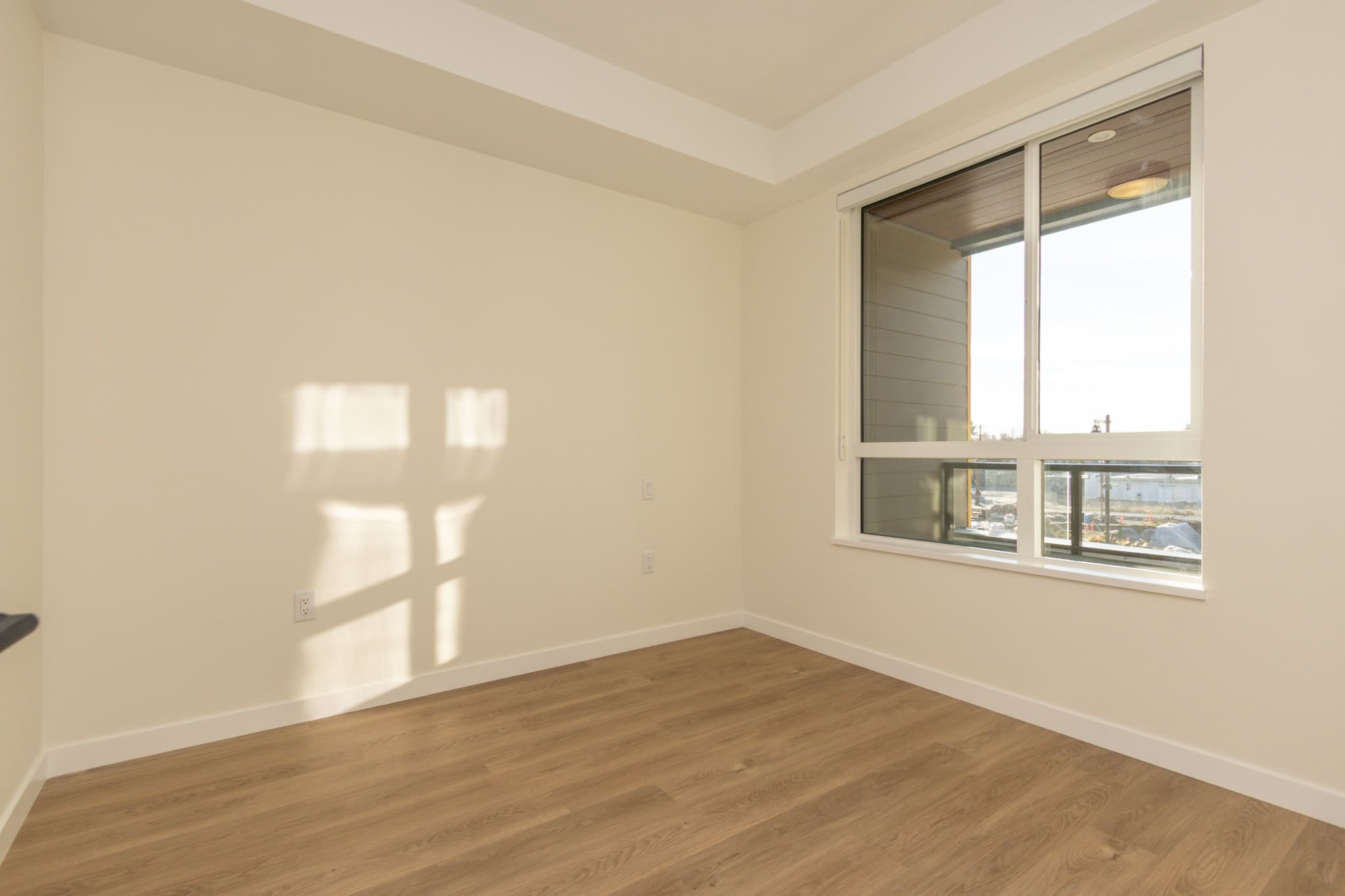 Bright empty room with large window, new flooring, modern design, ideal for real estate investment or home purchase in Vancouver, BC, by Orca Realty Inc.
