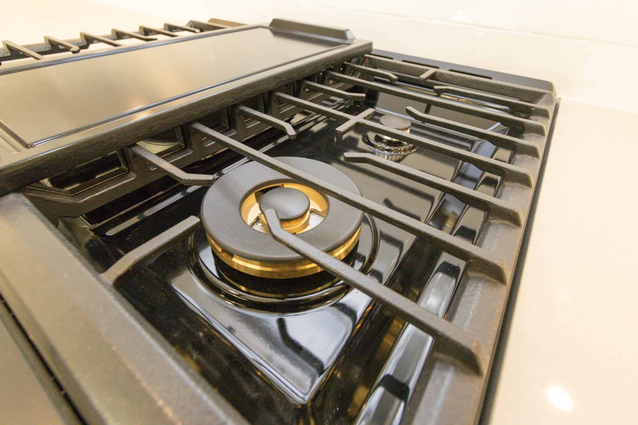 High-quality close-up image of modern gas stove top in a contemporary kitchen, showcasing sleek black finish, burners, and grates, ideal for real estate listings and interior home features.