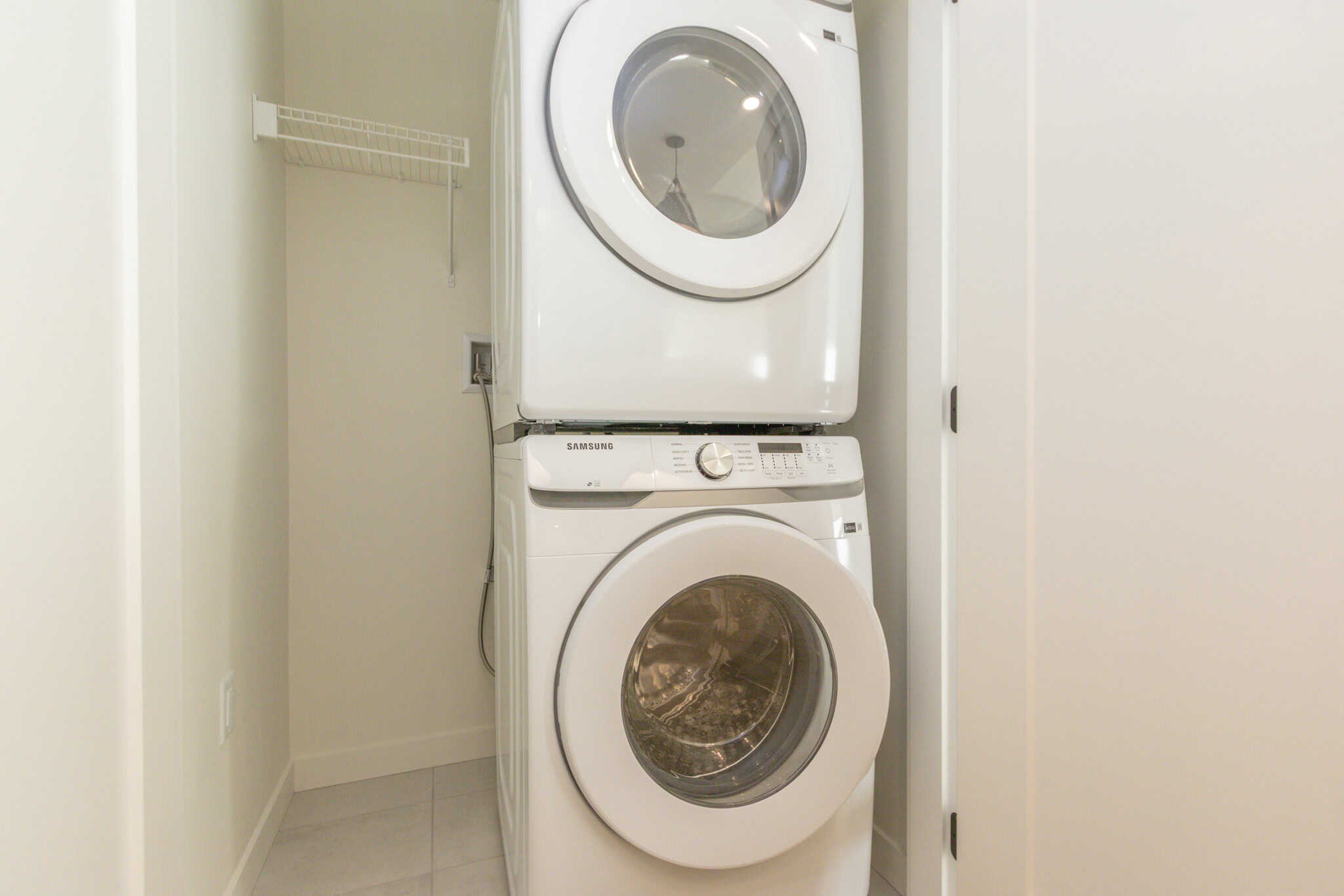 Modern laundry room with stacked washer and dryer, ideal for Vancouver real estate listings, showcasing functional and stylish laundry solutions in a contemporary home.