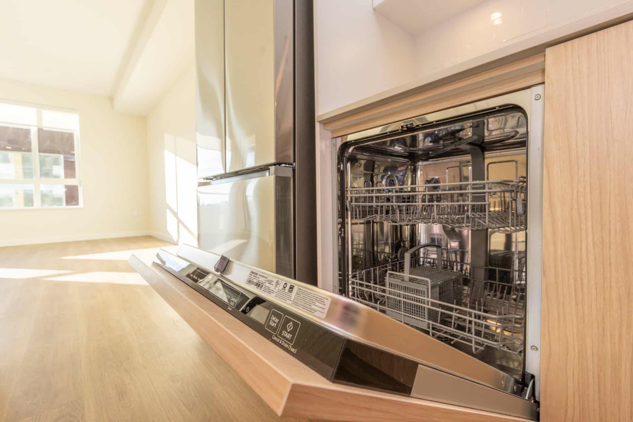 Modern kitchen with built-in dishwasher and natural light in a contemporary home in Vancouver, BC. Perfect for homebuyers seeking stylish amenities and functional design.