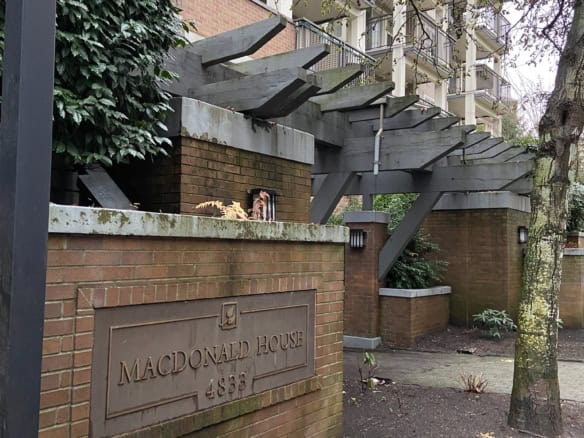 Elegant apartment building entrance with modern architectural details and lush greenery, showcasing the sophisticated living spaces in Vancouver's prime neighbourhoods.