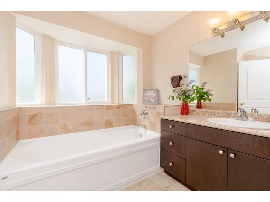 Spacious bathroom with large frosted windows, bathtub, and modern vanity for Vancouver or Victoria real estate listings. Perfect for home buyers seeking comfort and style.