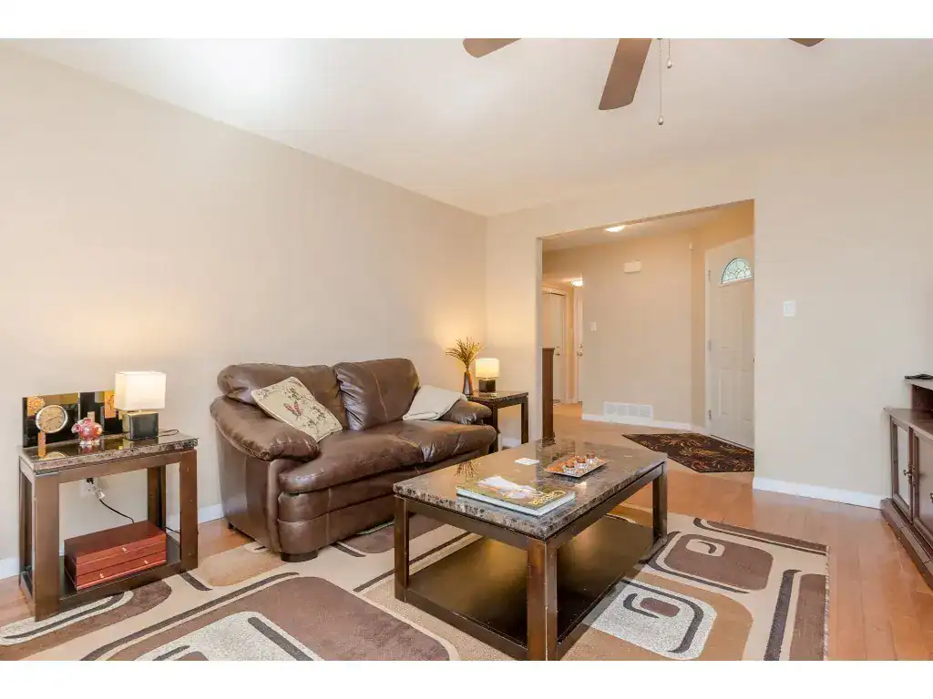 Cozy living room with beige walls, leather sofa, coffee table, and modern decor, ideal for Vancouver real estate buyers seeking comfortable, stylish homes in a welcoming neighbourhood.