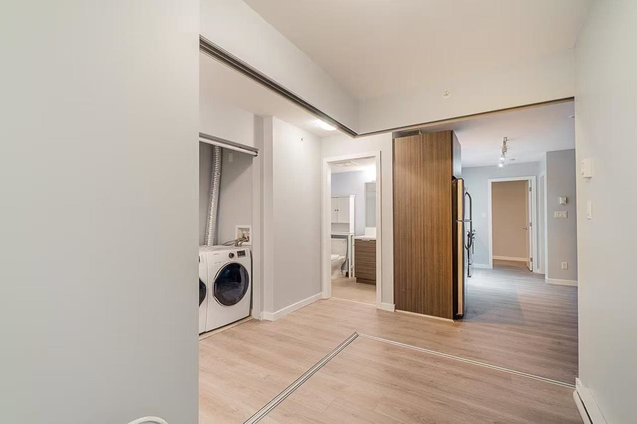 image0 Bright and modern laundry area featuring a front-load washer and dryer, open-concept design, and seamless transition to living and kitchen spaces, ideal for Vancouver real estate.
