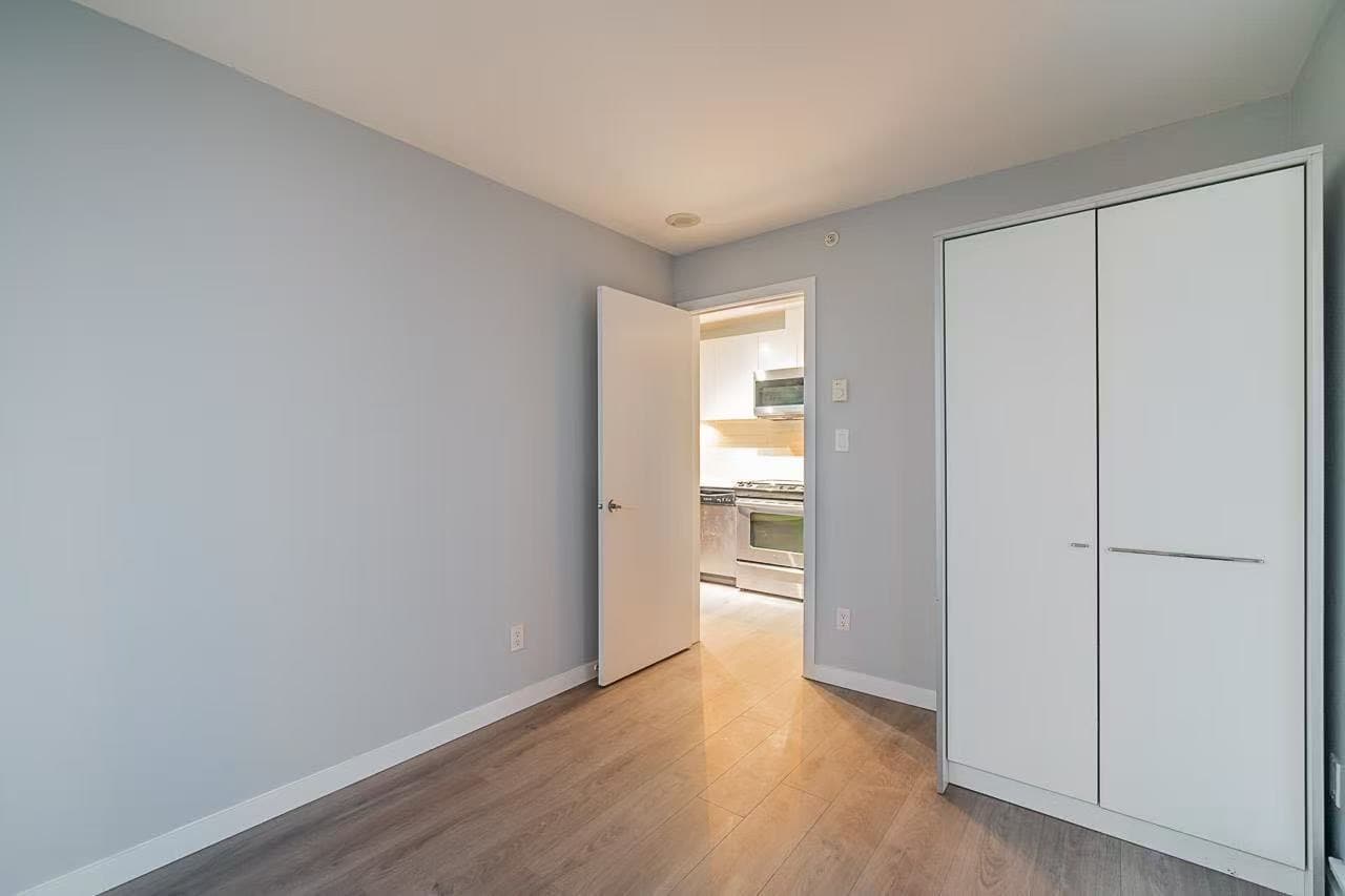 image16 Bright modern bedroom with light grey walls, hardwood flooring, and built-in closet, featuring easy access to a fully equipped kitchen, perfect for comfortable living in Vancouver.