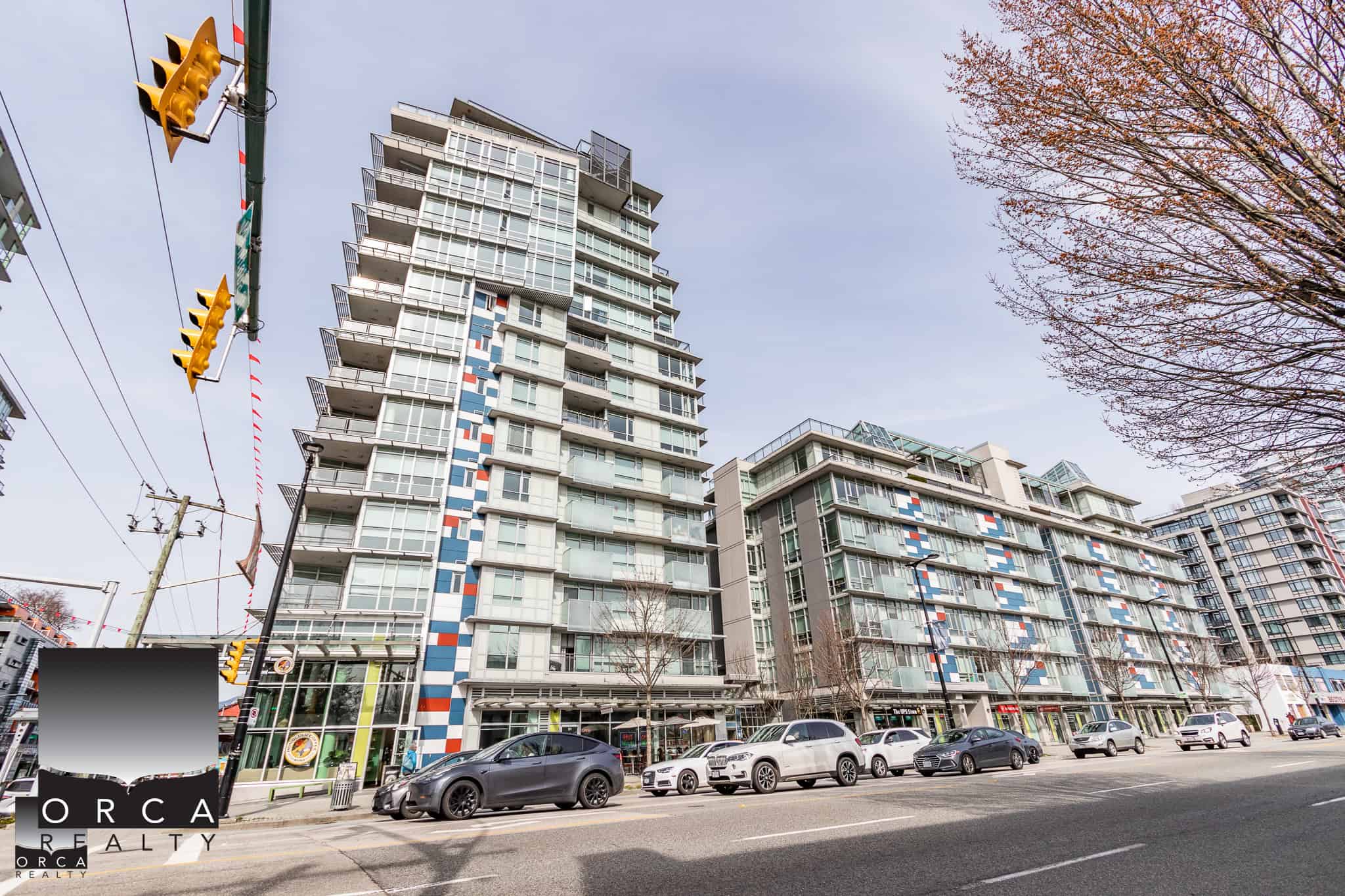 Modern multi-storey residential buildings in downtown Vancouver with retail spaces on the ground floor, stylish glass balconies, and vibrant exterior design, ideal for real estate investment and urban living.
